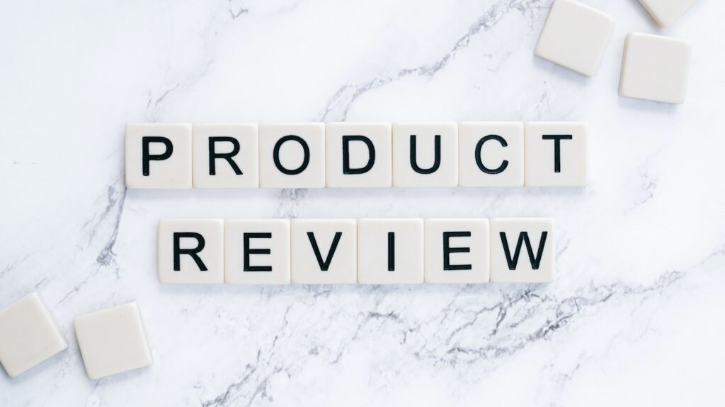 Scrabble tiles are arranged on a marble background to spell out "Product Review."