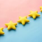 Five yellow 3D stars are in a diagonal line between a pink and a blue background.